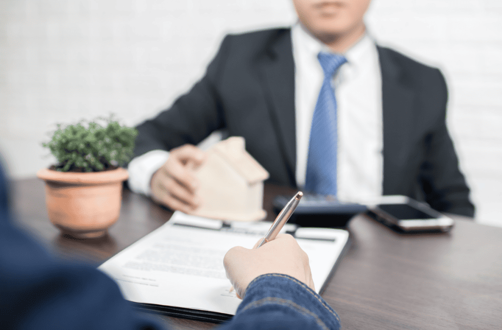Man signing form in front of mortgage lender